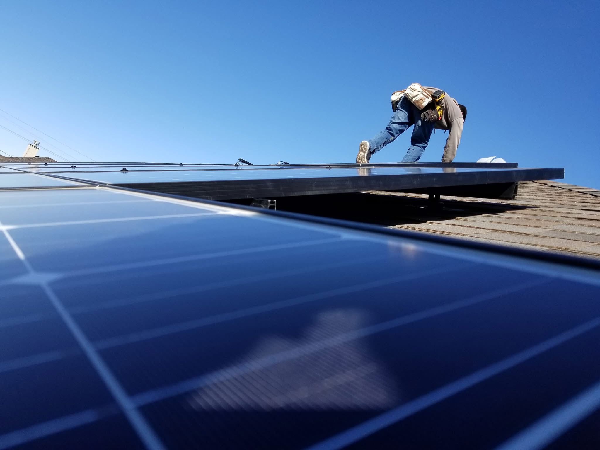 Technician servicing a solar panel installation on a roof