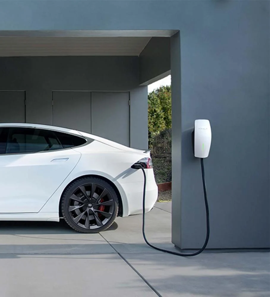Tesla Wall Connector charging a car in a garage